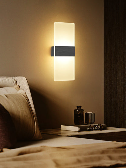 Wall-mounted light fixture on a wall above a bed in a bedroom setting.