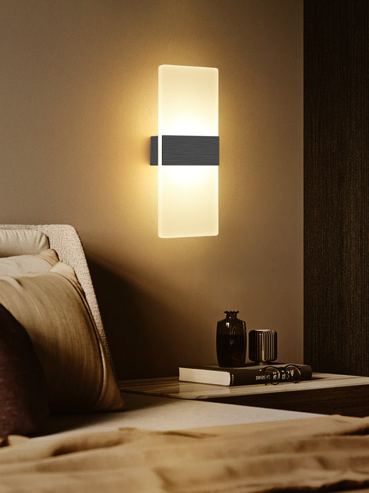 Wall-mounted light fixture on a wall above a bed in a bedroom setting.